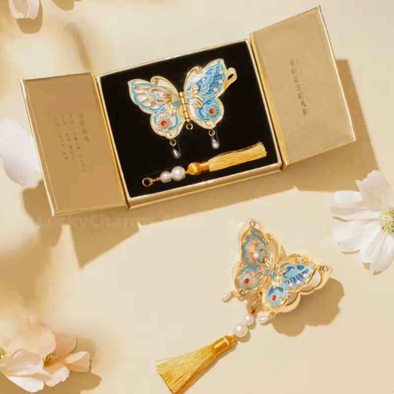 Palace Museum butterfly solid perfume compact in gold gift box with pearl tassel attachment.