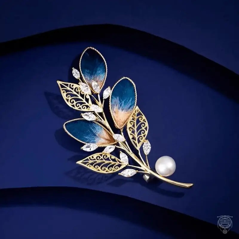 Handmade velvet flower brooch featuring blue leaf petals, gold filigree, cubic zirconia, and a freshwater pearl.