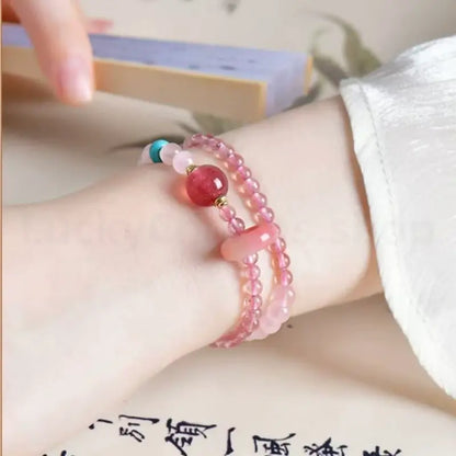 On-wrist view of a lady wearing the double-layer pink quartz love attraction crystal bracelet in a vintage setting