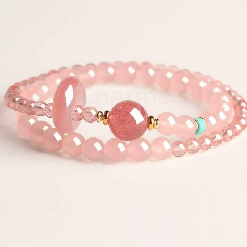 Natural strawberry quartz and pink rose quartz double-strand love luck bracelet with a turquoise bead on a white background