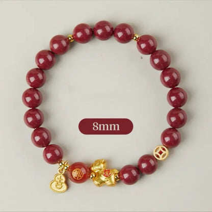 An 8mm natural cinnabar gemstone bracelet featuring protective red agate and a gold-plated lucky horse amulet.