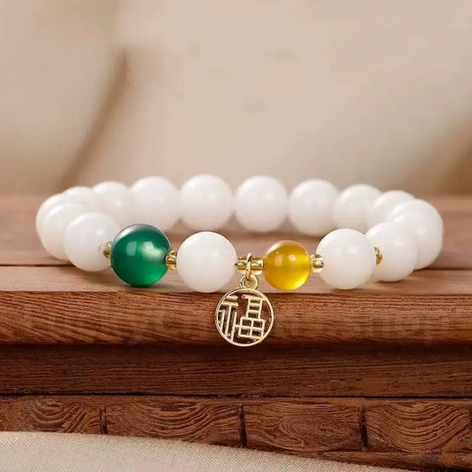 An 8mm white jade bodhi bead blessing bracelet with a vibrant green chalcedony bead and a dangling gold-plated Chinese Fu character charm.