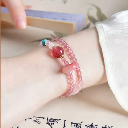 On-wrist view of a lady wearing the double-layer pink quartz love attraction crystal bracelet in a vintage setting