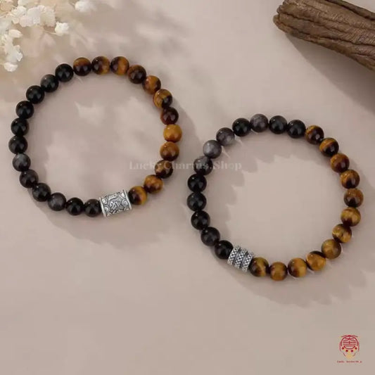 Two natural tiger's eye and obsidian protection bracelets with sterling silver mantra charm spacer beads.