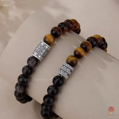 Side view of two natural gemstone mindfulness bracelets displaying polished chatoyant beads and silver spacers.