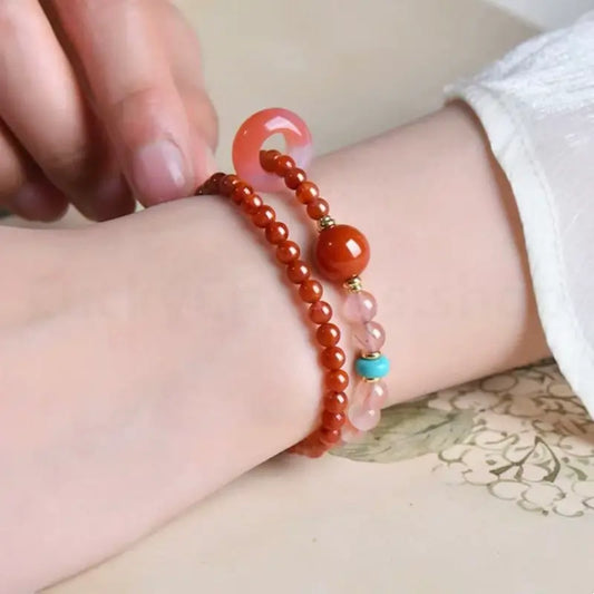 A woman wearing a Southern Red Agate crystal healing bracelet with a turquoise accent for positive energy.