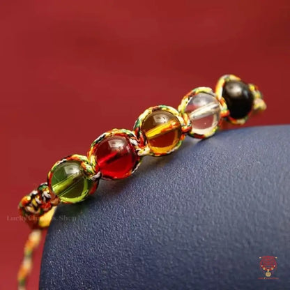 Detailed shot of the colorful braided protection knot bracelet showing five polished spiritual crystal beads.