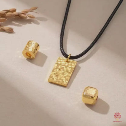 Collier avec pendentif géométrique en or martelé et cordon en cuir noir