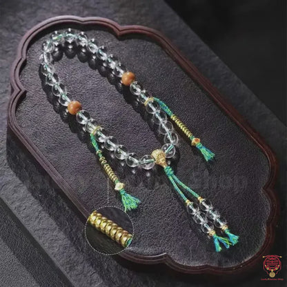 Le Mantra Strand Éthéré - Quartz Clair de Qualité Supérieure 10mm avec Roue à Six Syllabes Plaqué Or & Pompon