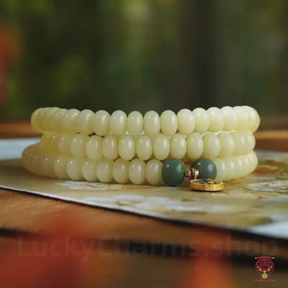 Le mala souverain – Chapelet de jade blanc Bodhi bio 6x8 mm et de perles dorées Dharma Wheel